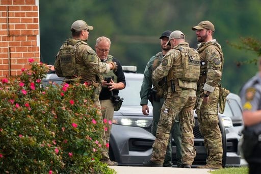 After catching escaped murderer, officers took a photo with him