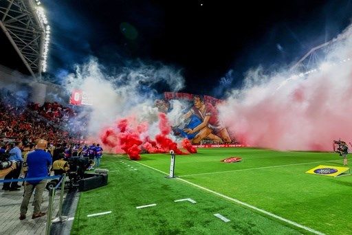 Israeli soccer game abandoned after rioting rival fans throw flares and smoke grenades