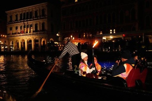 Olympic flame makes historic passage down Venice's Grand Canal